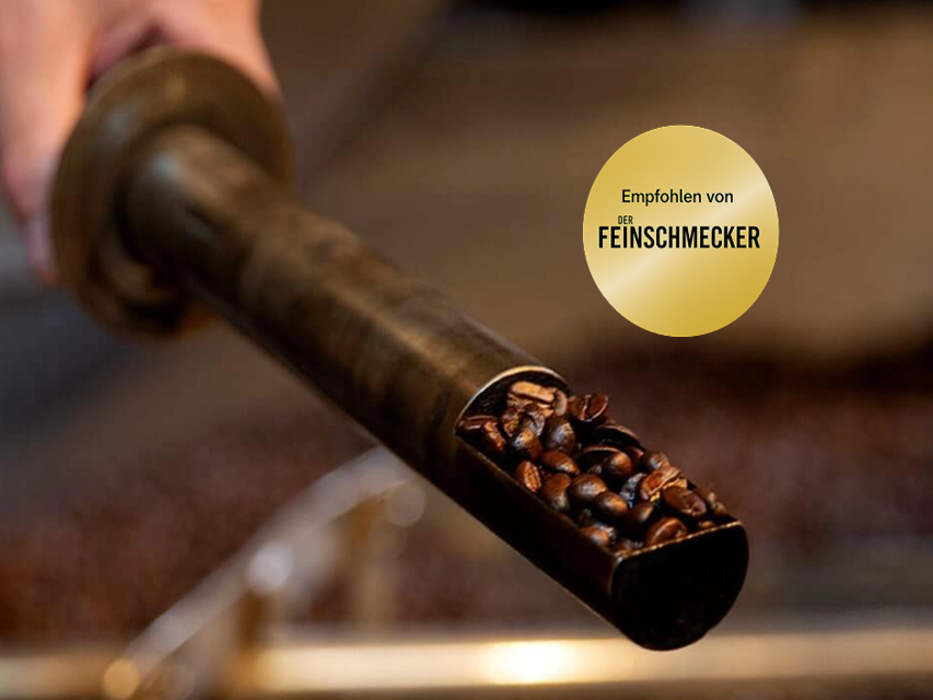 Frisch geröstete Kaffeebohnen, die aus einem Röstgerät gegossen werden, zeigen die Leidenschaft für die Zubereitung von Qualitätskaffee.