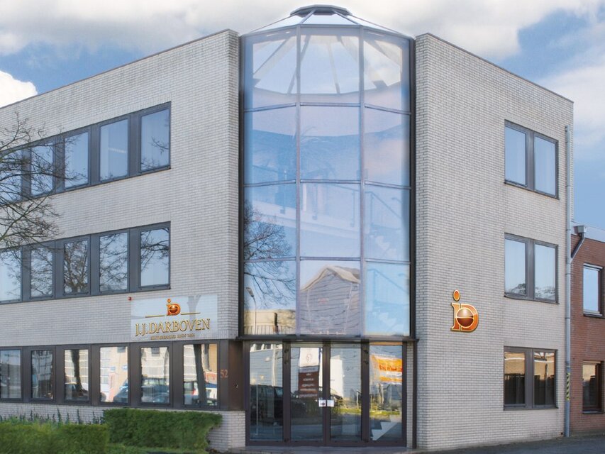 Modernes Bürogebäude mit großem Glaseingang und J.J. Darboven-Schriftzug in einem Geschäftsviertel.