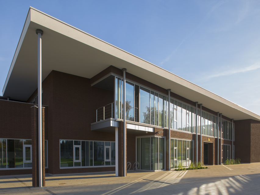 Modernes Hauptquartier mit großen Glasfenstern und eleganter Architektur vor einem strahlend blauen Himmel.