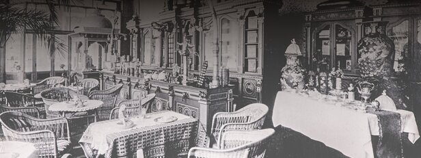 Historische Café-Einrichtung mit eleganten Möbeln und Dekorationsstücken, die den Charme und den Stil der alten Zeit widerspiegeln.