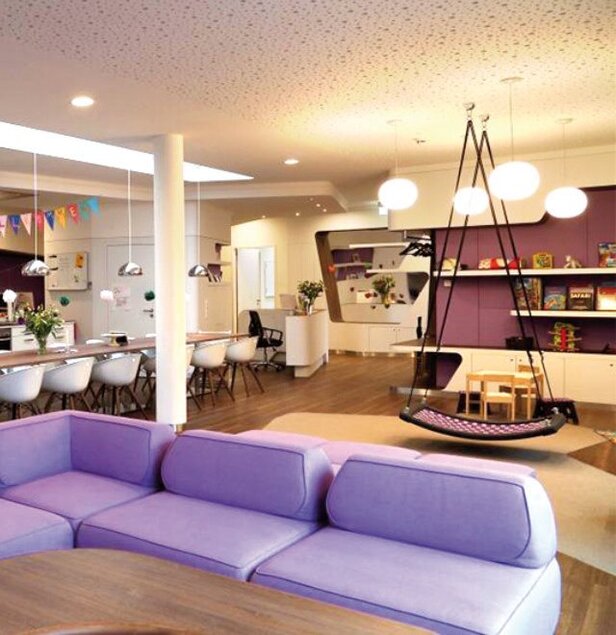 Modern play area with purple seating and a swing, designed for children's comfort and creativity in a McDonald's setting.