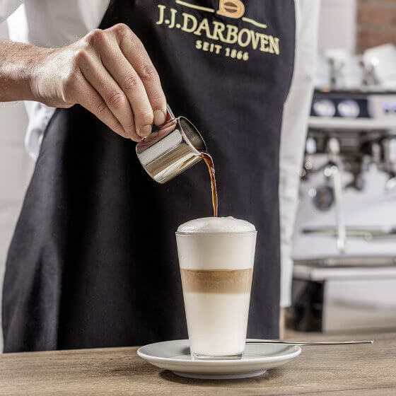 A latte macchiato is prepared with Darboven coffee.