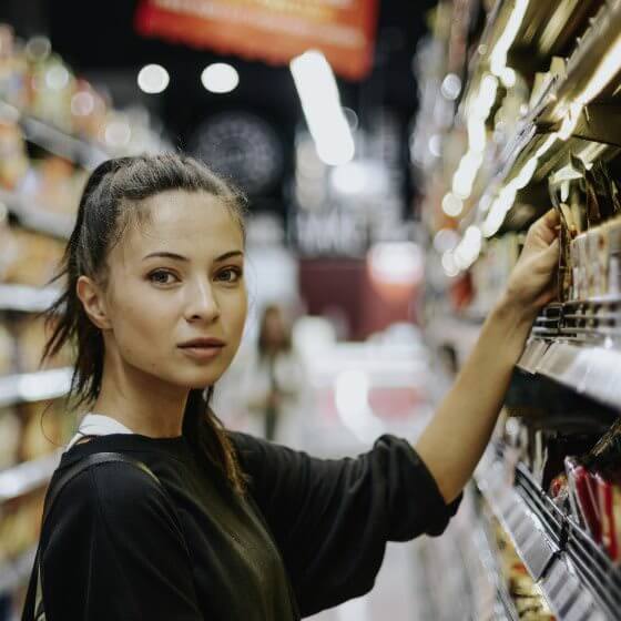 A young woman buys Darboven coffee in the supermarket.